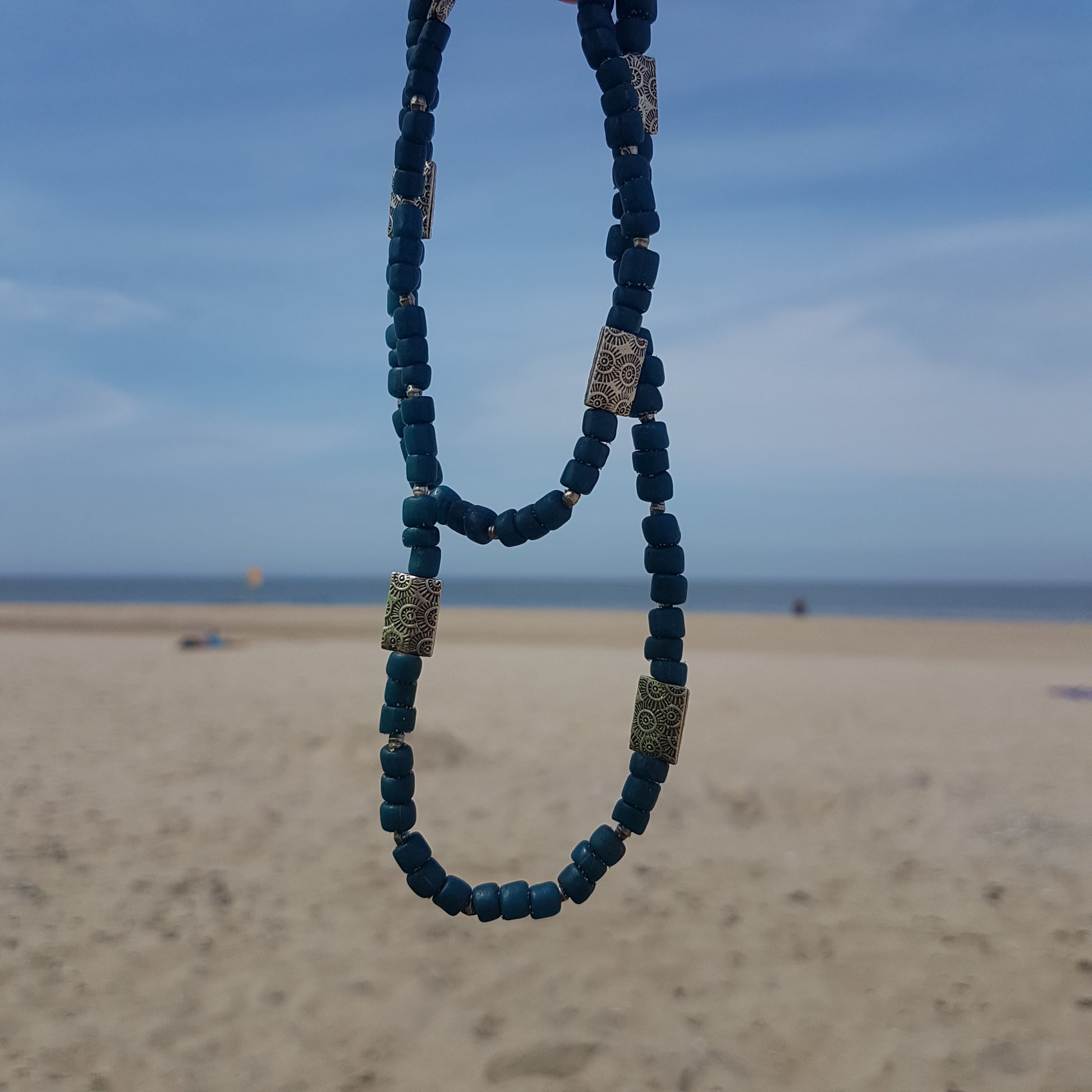 Handgearbeitete Kette/ dreireihiges Armband mit petrolfabenen Glasperlen von der Insel Java und gehämmerten burmesischen Silberperlen auf Gummiband