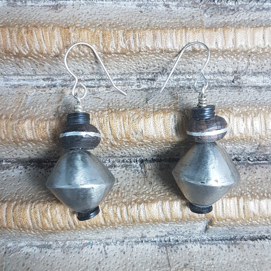 Handgefertigte Ohrhänger mit holen Metallperlen und Ebenholzperlen mit Metallintarsien der Tuareg und schwarzen afrikanischen Bakelitscheiben am Silberhaken