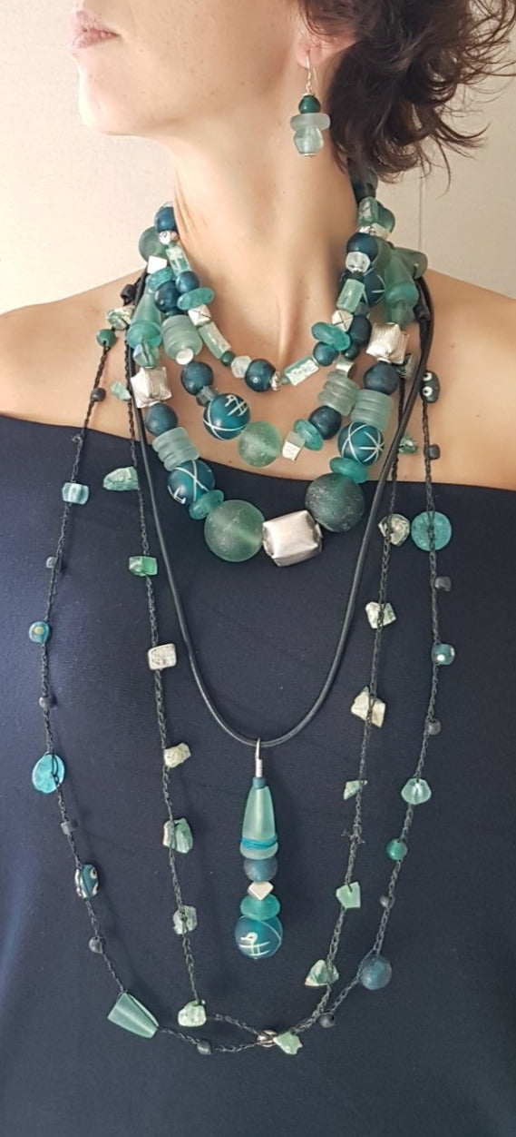 Lange handgehäkelte Kette, ein Mix aus afrikanischen und indonesischen Glasperlen in Aquamarintönen, Harzperlen und Silberschnecken aus Burma auf Baumwolle