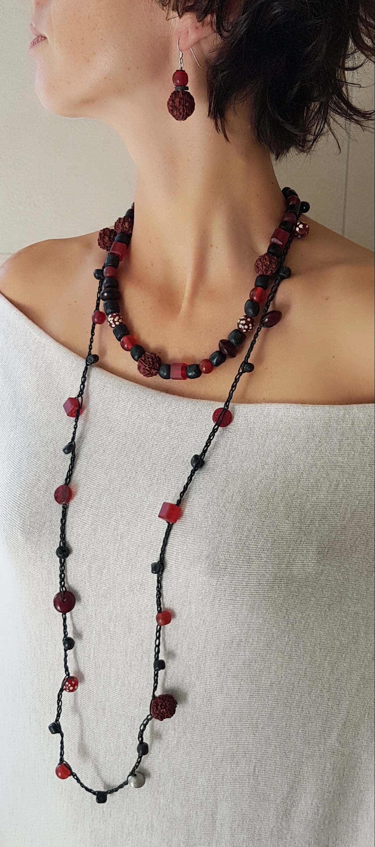 Lange handgehäkelte Kette mit Rudraksha-Samen aus nepalesischen Gebets-Malas, schwarzen indonesischen Wickelglasperlen, Harzperlen in Rottönen und roten Glasperlen von der Insel Java auf Baumwolle