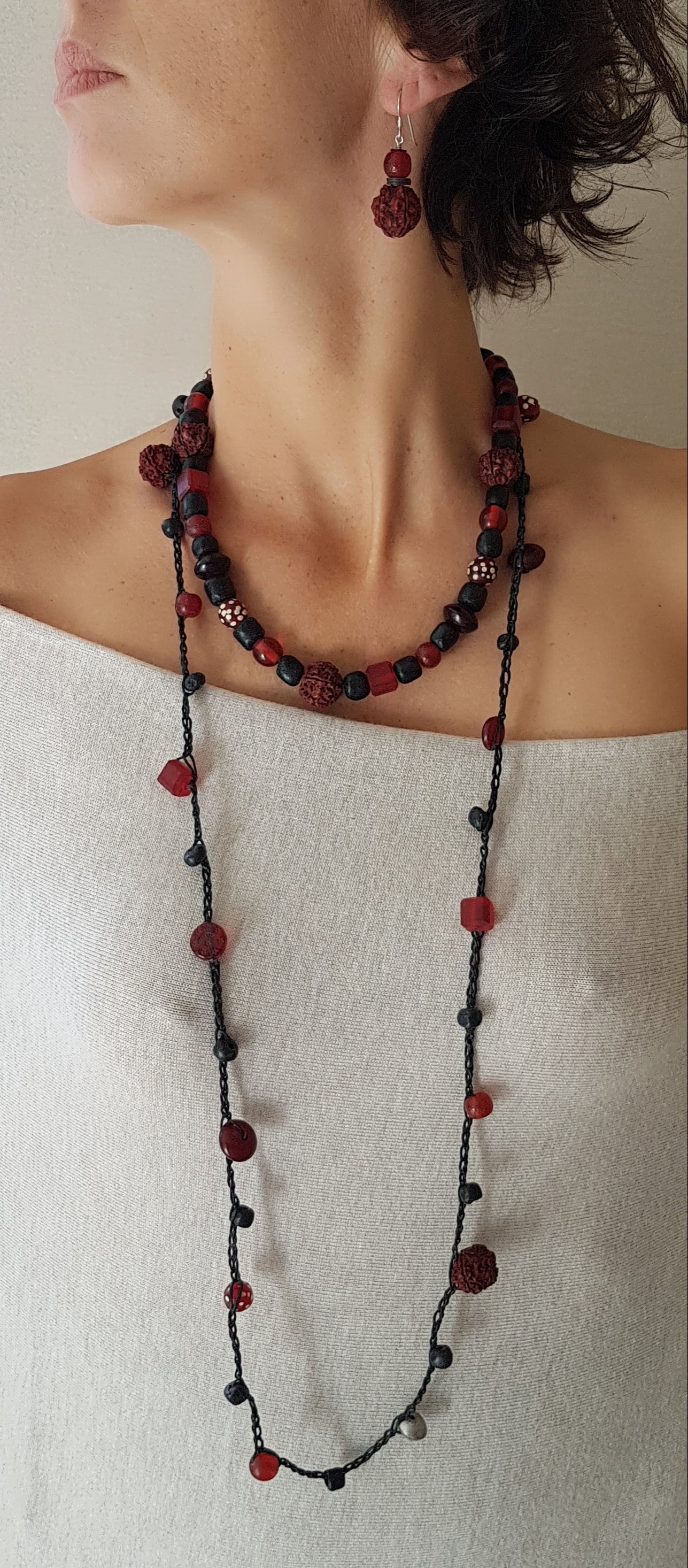 Lange handgehäkelte Kette mit Rudraksha-Samen aus nepalesischen Gebets-Malas, schwarzen indonesischen Wickelglasperlen, Harzperlen in Rottönen und roten Glasperlen von der Insel Java auf Baumwolle