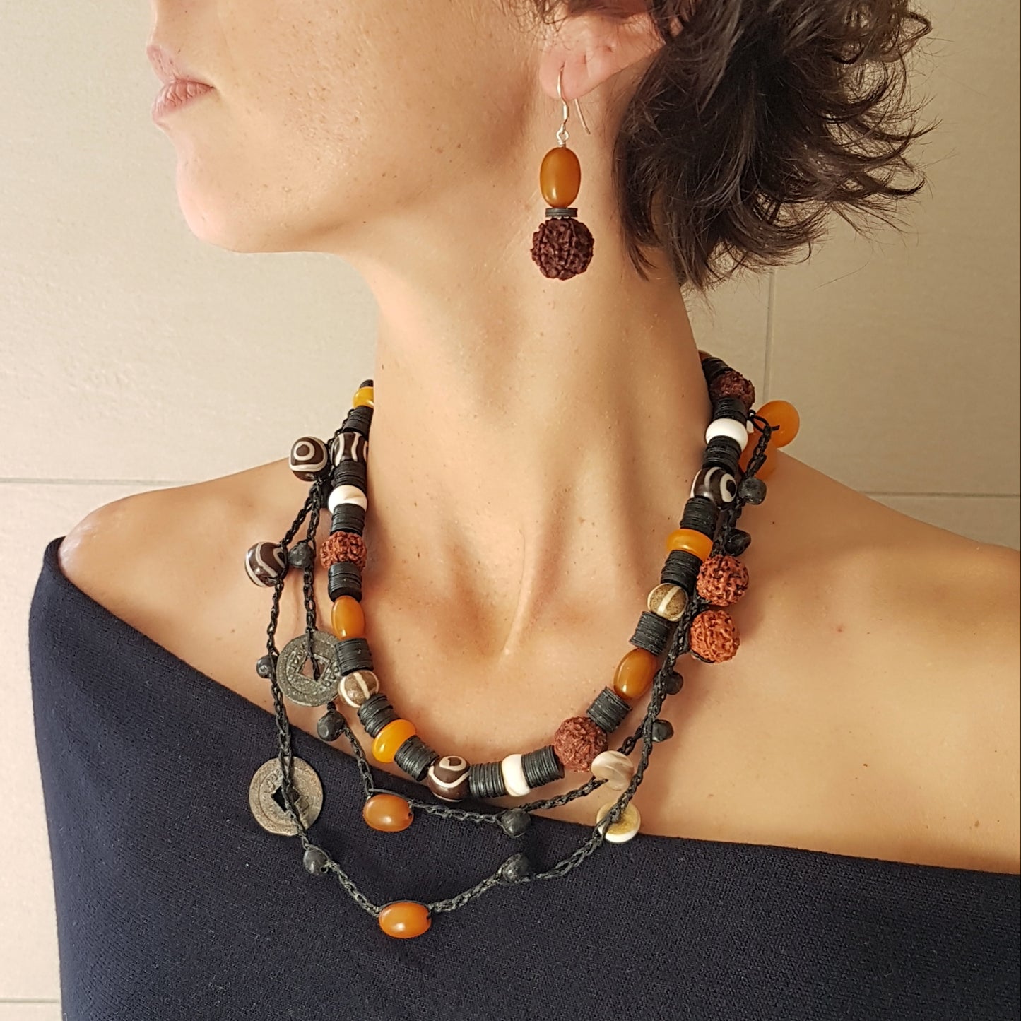 Lange handgehäkelte Kette mit Rudraksha-Samen aus nepalesischen Gebets-Malas, schwarzen indonesischen Wickelglasperlen, braunen und gelben Harzperlen, weißen Shiva-Muscheln und gestreiften Perlen aus versteinertem Holz aus Burma auf Baumwolle