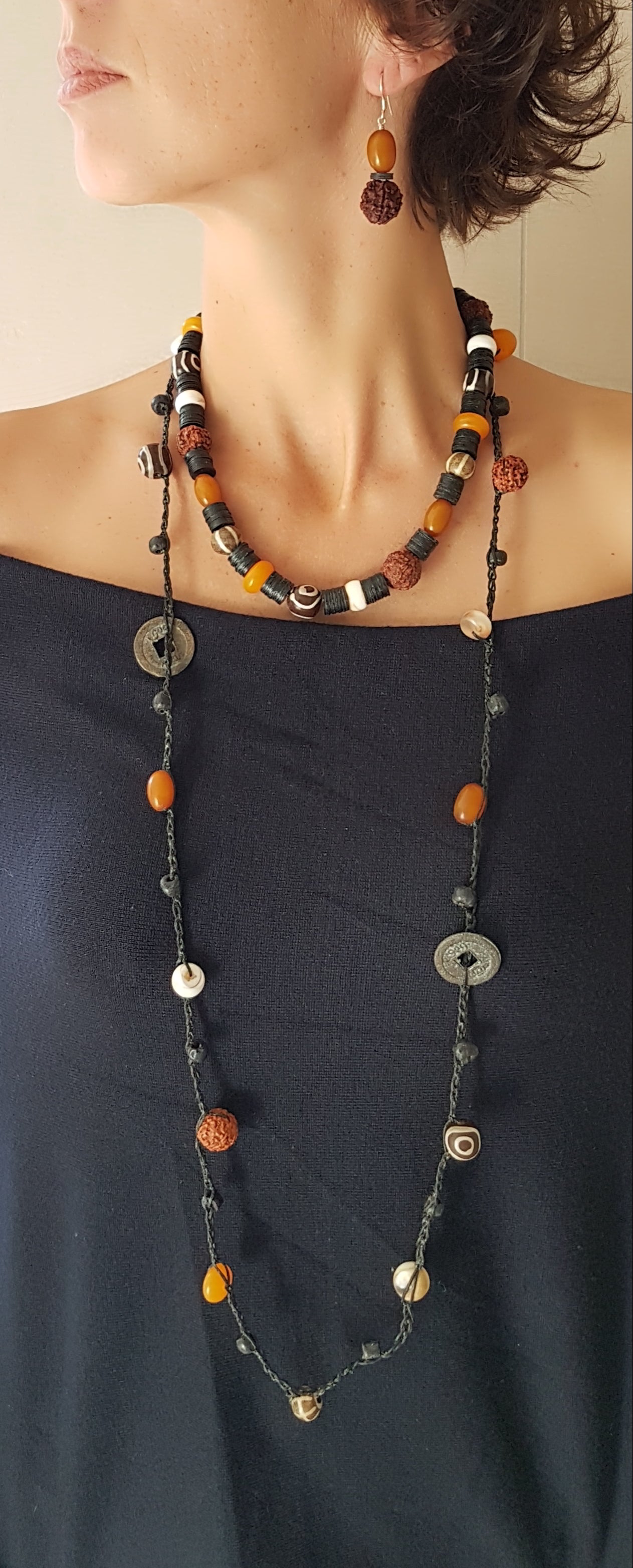 Lange handgehäkelte Kette mit Rudraksha-Samen aus nepalesischen Gebets-Malas, schwarzen indonesischen Wickelglasperlen, braunen und gelben Harzperlen, weißen Shiva-Muscheln und gestreiften Perlen aus versteinertem Holz aus Burma auf Baumwolle