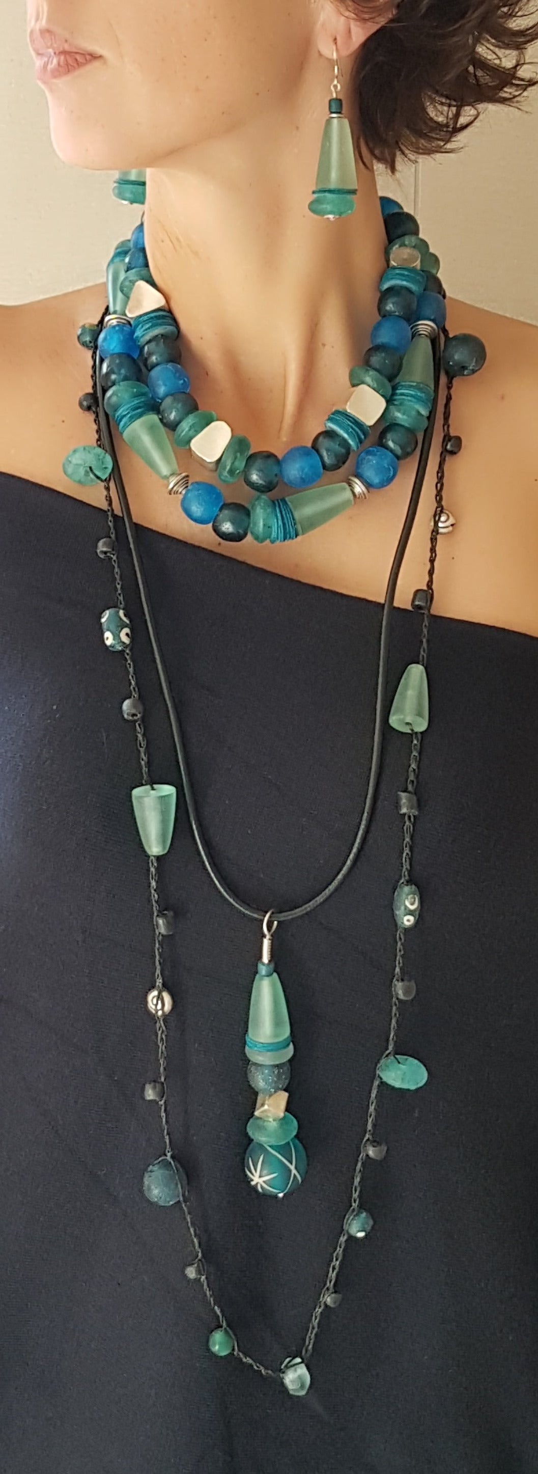 Lange handgehäkelte Kette, ein Mix aus afrikanischen und indonesischen Glasperlen in Aquamarintönen, Harzperlen und Silberschnecken aus Burma auf Baumwolle
