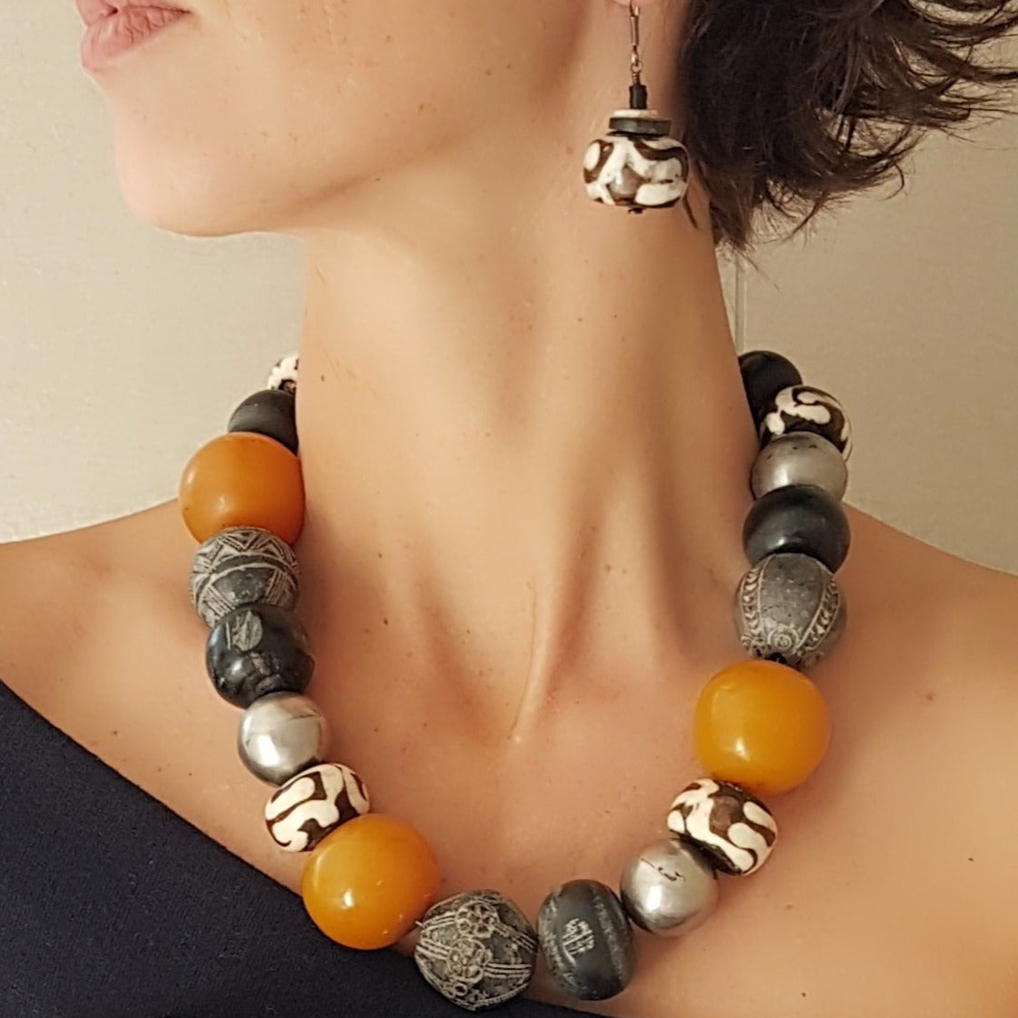 Handgefertigte Ohrhänger mit gebatikten Beinperlen aus Afrika, schwarzen afrikanischen Bakelit- und Kokosscheiben und hellen Scheiben aus Straußeneierschale am Silberhaken