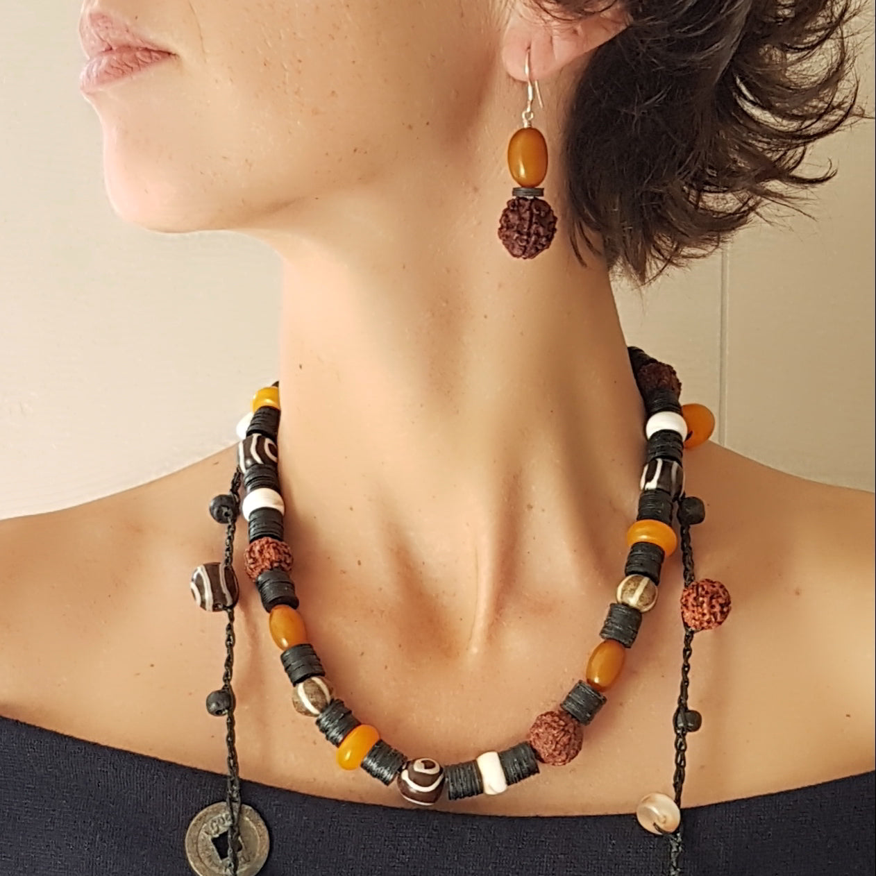 Lange handgehäkelte Kette mit Rudraksha-Samen aus nepalesischen Gebets-Malas, schwarzen indonesischen Wickelglasperlen, braunen und gelben Harzperlen, weißen Shiva-Muscheln und gestreiften Perlen aus versteinertem Holz aus Burma auf Baumwolle