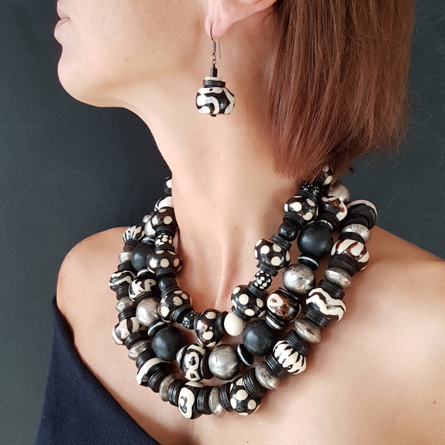 Handgearbeitete Kette mit gepunkteten gebatikten Beinperlen aus Afrika, schwarzen afrikanischen Bakelitscheiben und Perlen aus Glas, Muschel, Horn und Ebenholz mit Silberverschluss