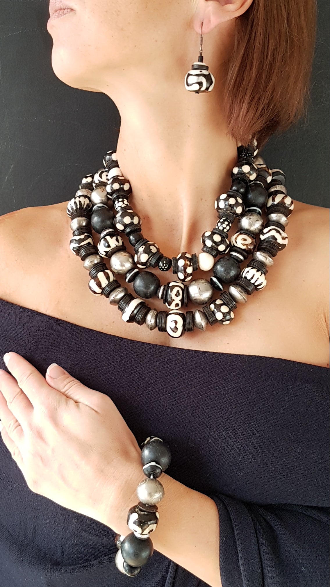 Handgearbeitete Kette mit gepunkteten gebatikten Beinperlen aus Afrika, schwarzen afrikanischen Bakelitscheiben und Perlen aus Glas, Muschel, Horn und Ebenholz mit Silberverschluss