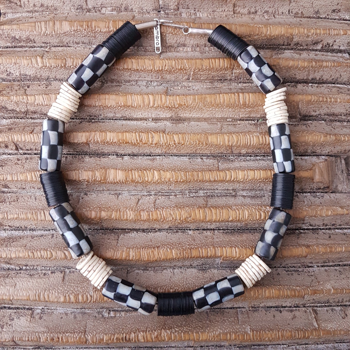 Handgearbeitete Kette mit schwarzweißen karrierten Glasperlen von der Insel Java, weißen Scheiben aus Straußeneierschale und schwarzen afrikanischen Bakelitscheiben mit Silberverschluss