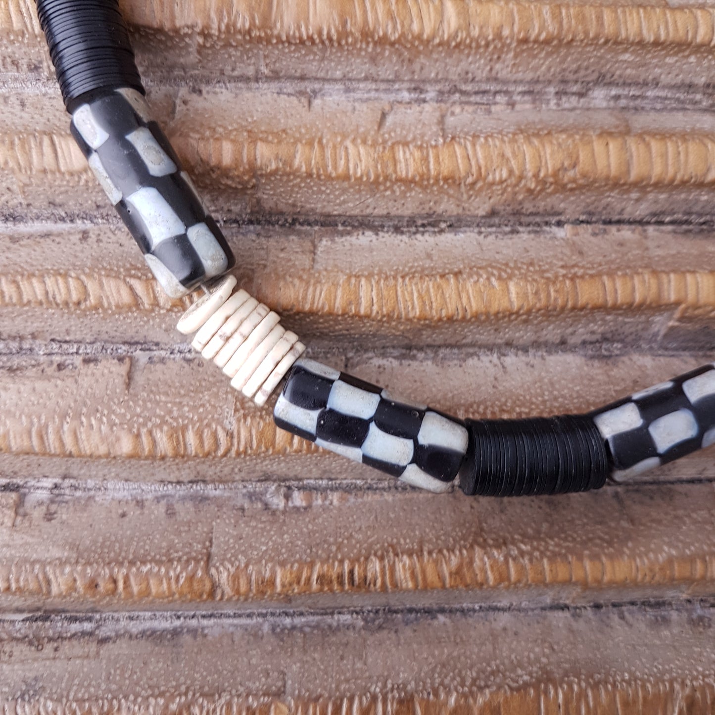 Handgearbeitete Kette mit schwarzweißen karrierten Glasperlen von der Insel Java, weißen Scheiben aus Straußeneierschale und schwarzen afrikanischen Bakelitscheiben mit Silberverschluss