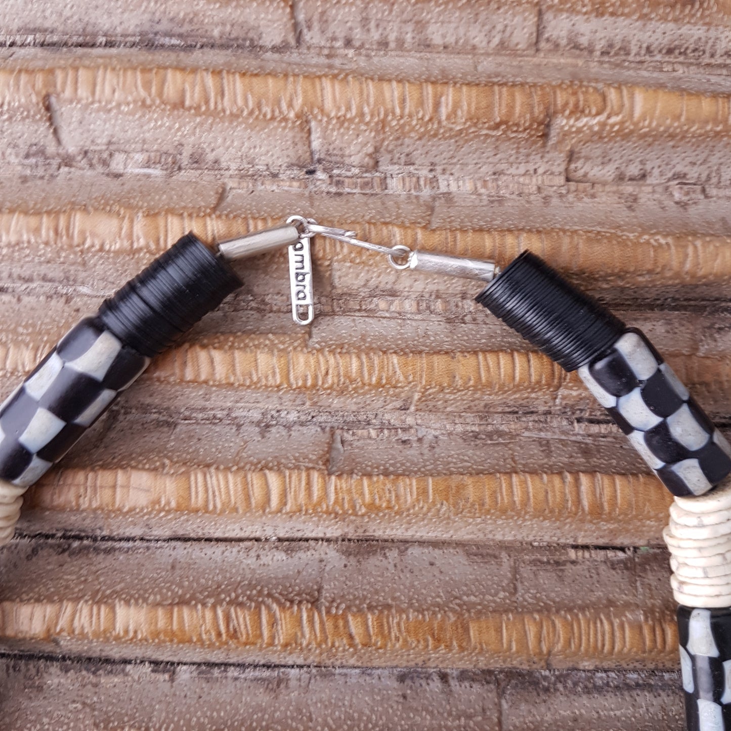 Handgearbeitete Kette mit schwarzweißen karrierten Glasperlen von der Insel Java, weißen Scheiben aus Straußeneierschale und schwarzen afrikanischen Bakelitscheiben mit Silberverschluss