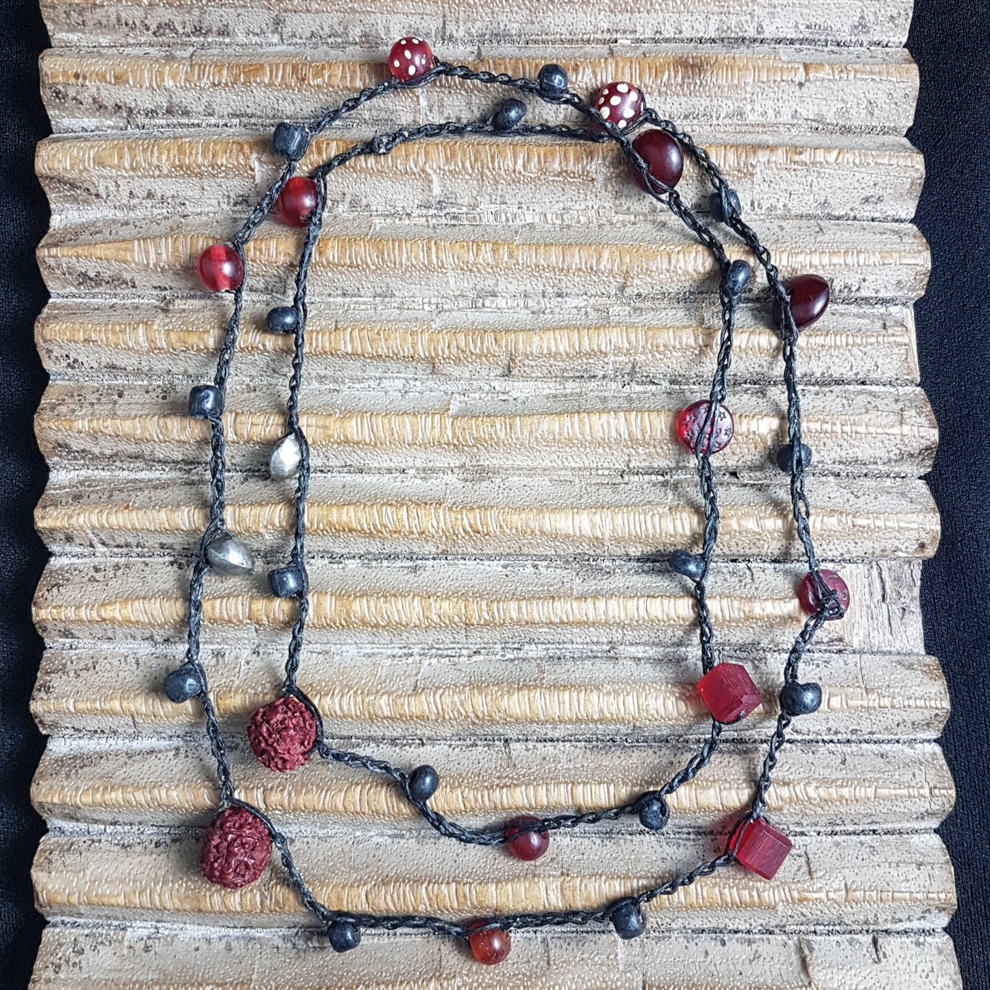 Lange handgehäkelte Kette mit Rudraksha-Samen aus nepalesischen Gebets-Malas, schwarzen indonesischen Wickelglasperlen, Harzperlen in Rottönen und roten Glasperlen von der Insel Java auf Baumwolle