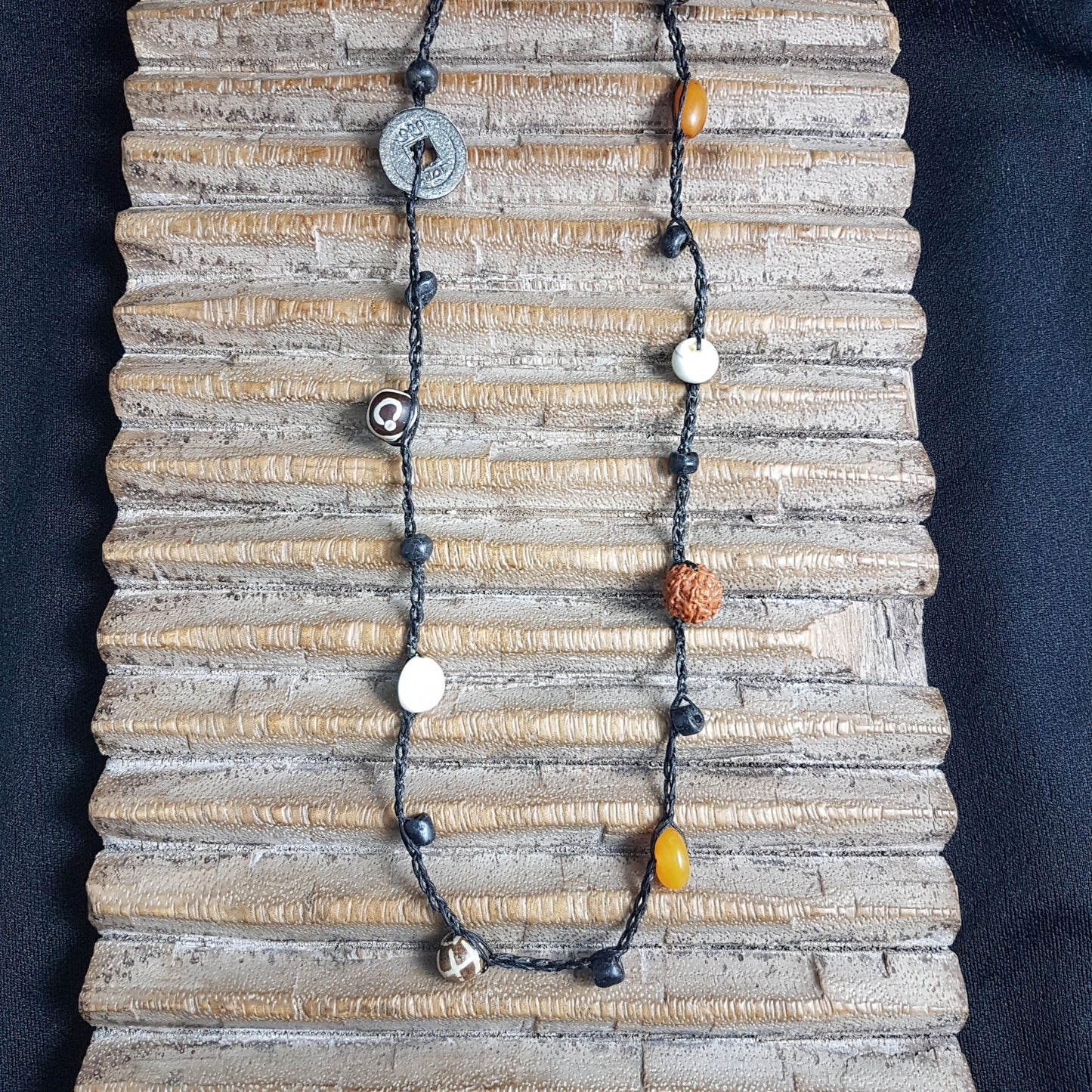 Lange handgehäkelte Kette mit Rudraksha-Samen aus nepalesischen Gebets-Malas, schwarzen indonesischen Wickelglasperlen, braunen und gelben Harzperlen, weißen Shiva-Muscheln und gestreiften Perlen aus versteinertem Holz aus Burma auf Baumwolle
