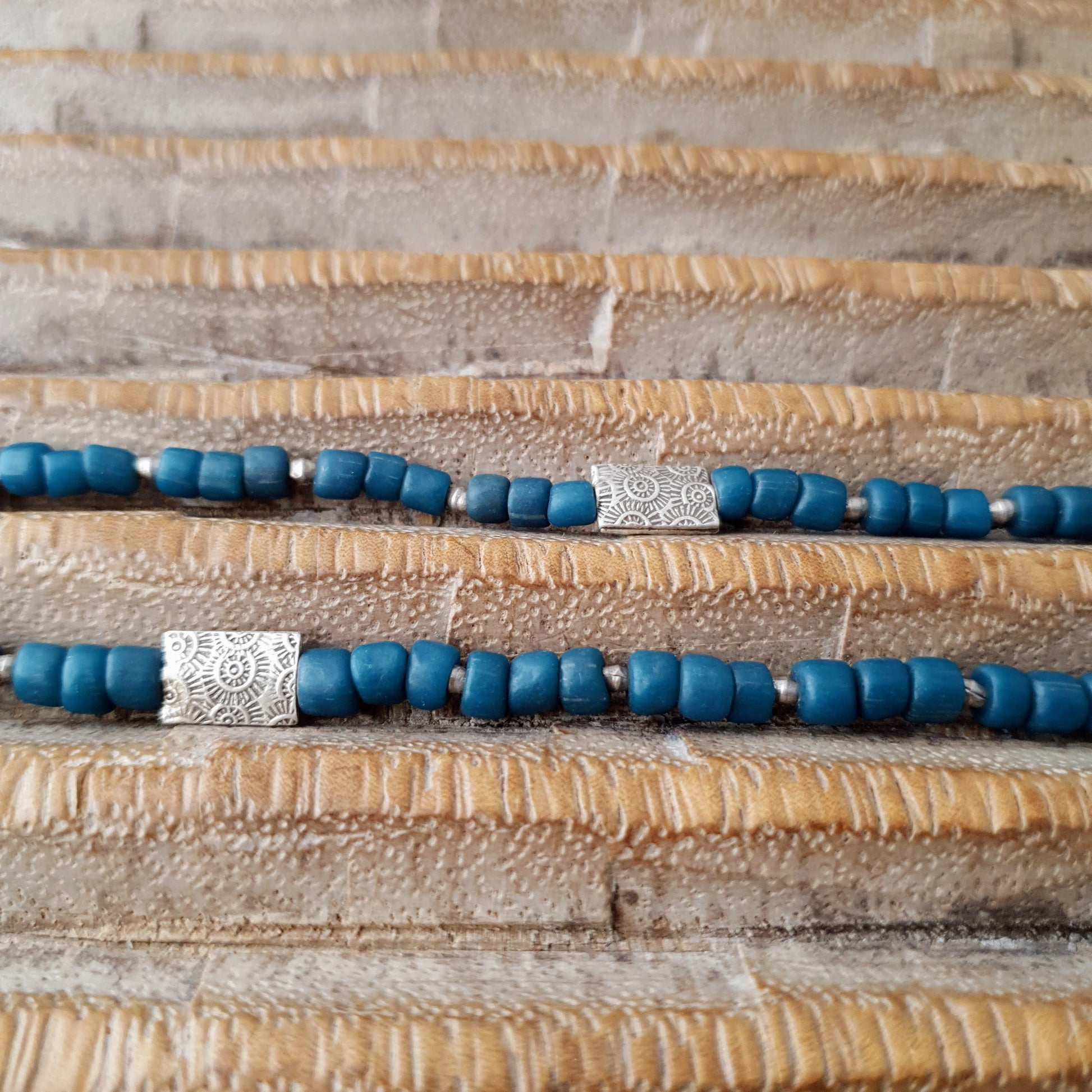 Handgearbeitete Kette/ dreireihiges Armband mit petrolfabenen Glasperlen von der Insel Java und gehämmerten burmesischen Silberperlen auf Gummiband