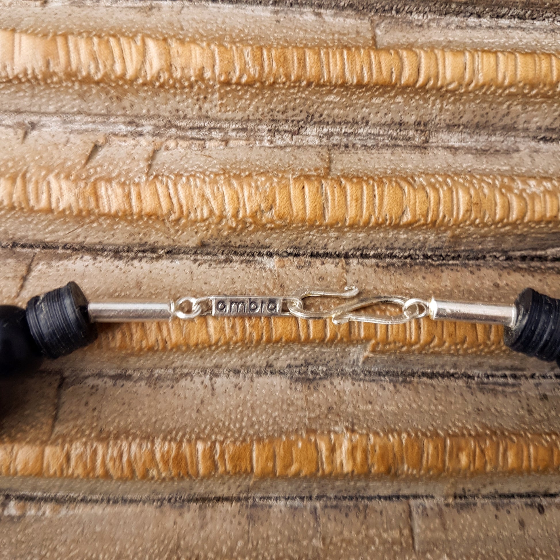 Handgearbeitete Kette mit gepunkteten gebatikten Beinperlen aus Afrika, schwarzen afrikanischen Bakelitscheiben und Perlen aus Glas, Muschel, Horn und Ebenholz mit Silberverschluss