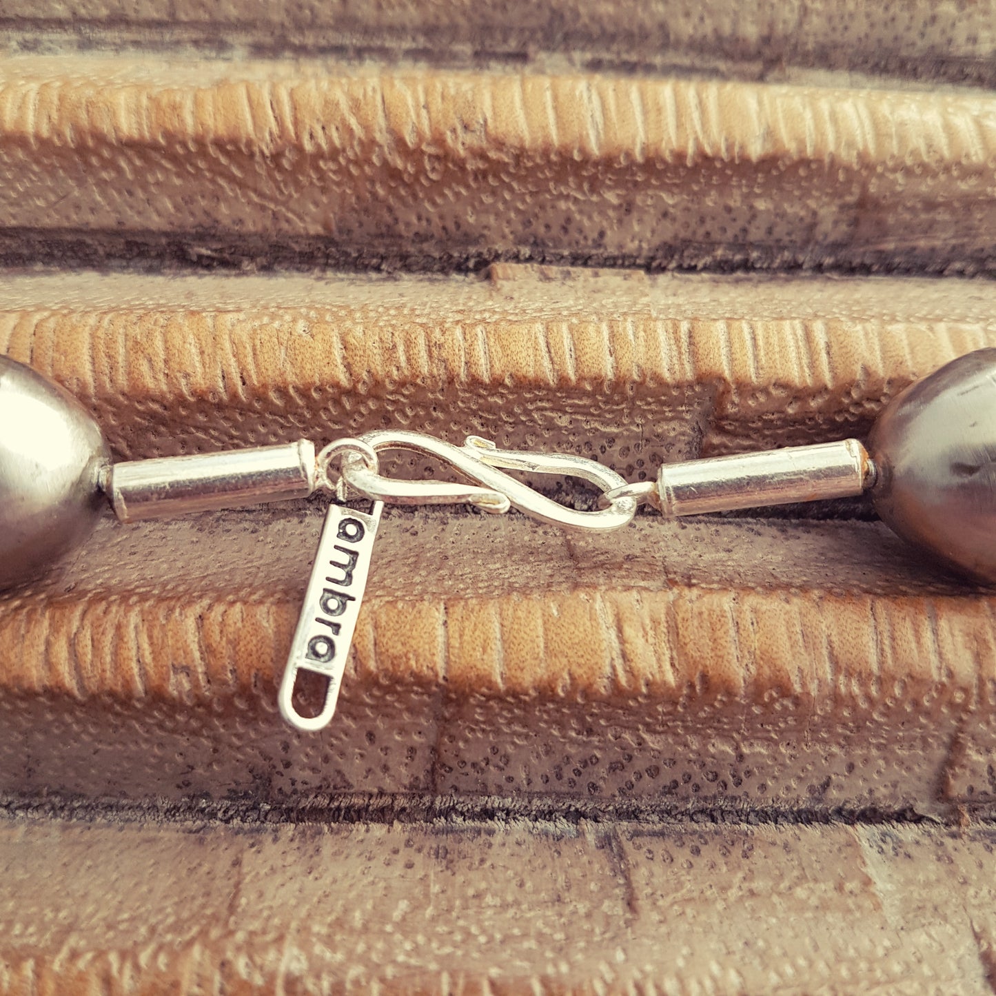 Handgearbeitete Kette mit nepalesischen Muscheln, versteinertem Holz und hohlen Metallperlen der Tuareg mit Silberverschluss