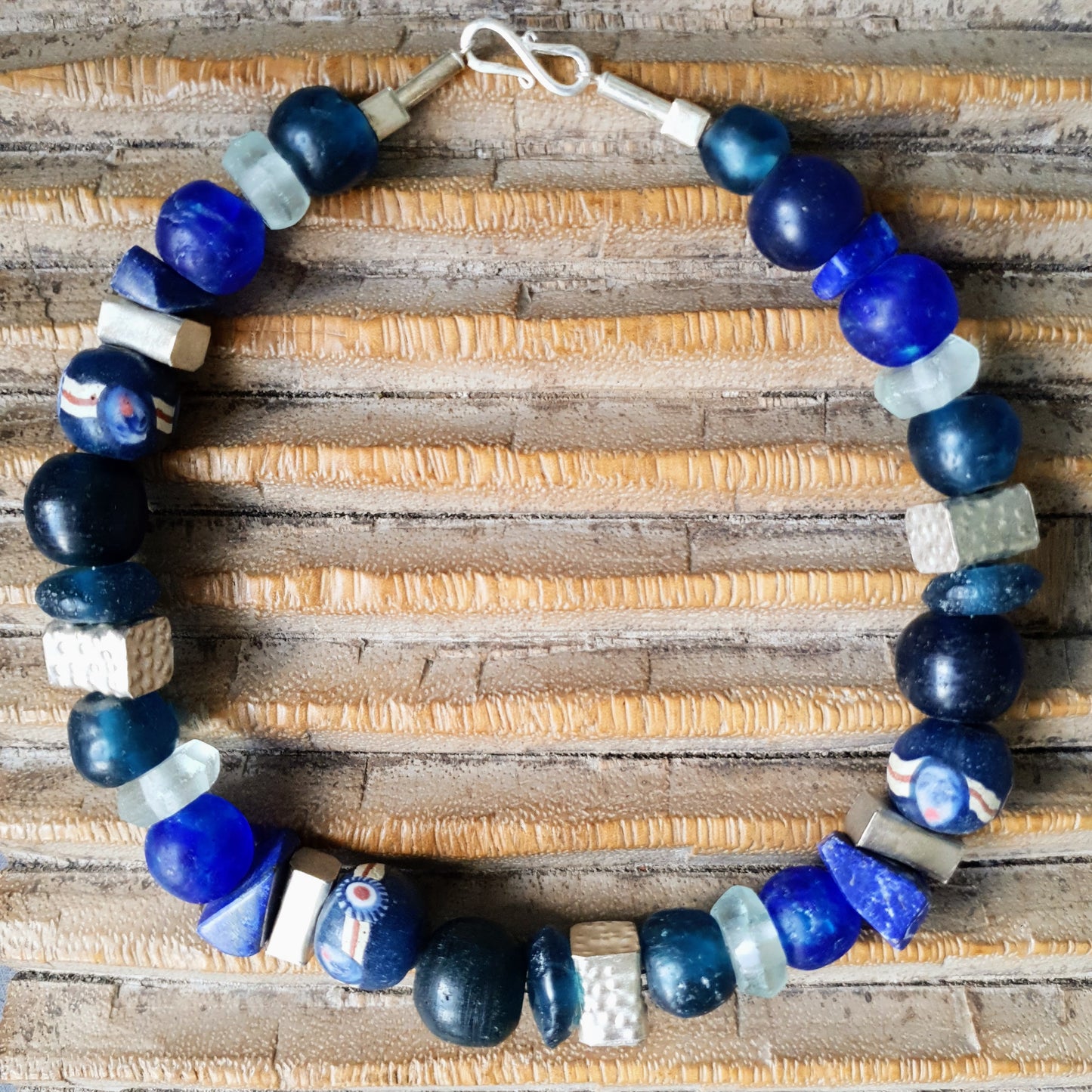 Handgearbeitete Halskette mit verschiedenen Glasperlen von der Insel Java und aus Afrika in Blau- und Türkistönen, blauen Lapislazulisteinen und eckigen gehämmerten Silberperlen aus Burma mit Silberverschluss von ambra Schmuck. Halskette│Glas│Lapislazuli│Burmasilber Glas (Java)/ Lapis/ Silber (Burma)