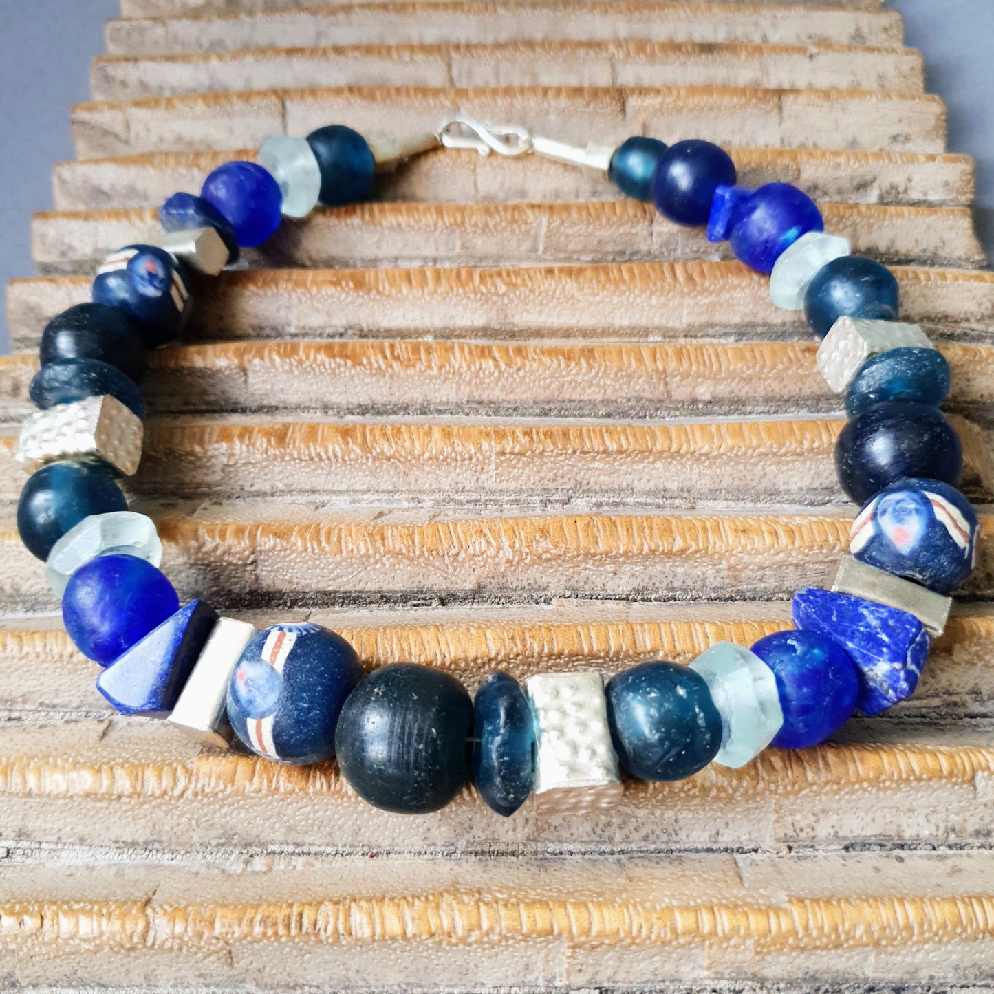 Handgearbeitete Halskette mit verschiedenen Glasperlen von der Insel Java und aus Afrika in Blau- und Türkistönen, blauen Lapislazulisteinen und eckigen gehämmerten Silberperlen aus Burma mit Silberverschluss von ambra Schmuck. Halskette│Glas│Lapislazuli│Burmasilber Glas (Java)/ Lapis/ Silber (Burma)