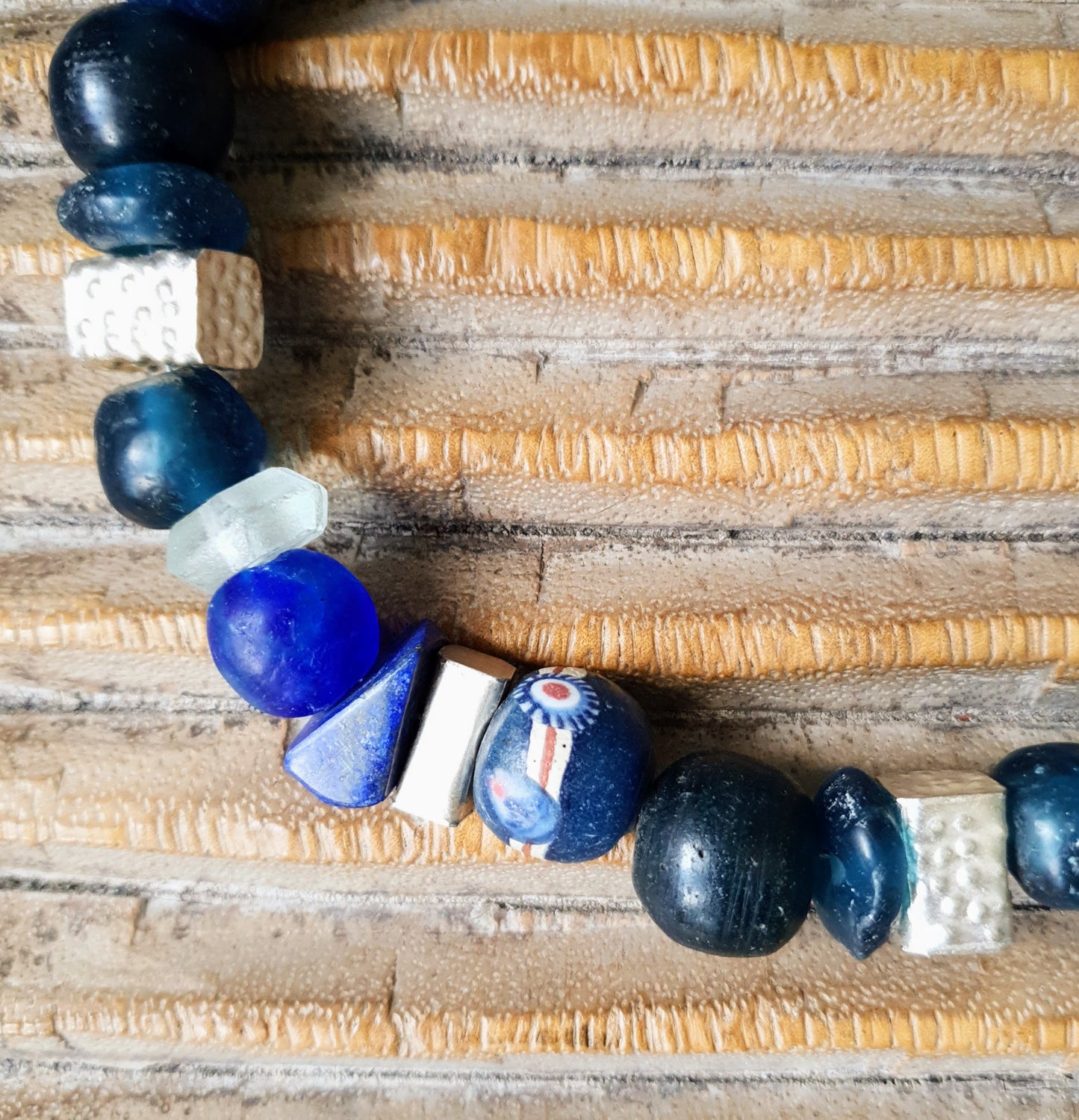 Handgearbeitete Halskette mit verschiedenen Glasperlen von der Insel Java und aus Afrika in Blau- und Türkistönen, blauen Lapislazulisteinen und eckigen gehämmerten Silberperlen aus Burma mit Silberverschluss von ambra Schmuck. Halskette│Glas│Lapislazuli│Burmasilber Glas (Java)/ Lapis/ Silber (Burma)