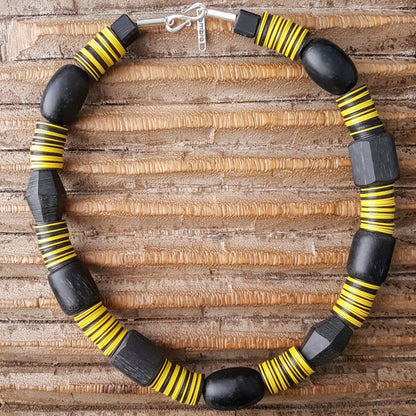 Handgearbeitete Kette mit schwarzen Harzperlen aus Indonesien und afrikanischen Bakelitscheiben in schwarz und gelb mit Silberverschluss