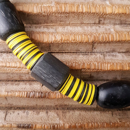 Handgearbeitete Kette mit schwarzen Harzperlen aus Indonesien und afrikanischen Bakelitscheiben in schwarz und gelb mit Silberverschluss